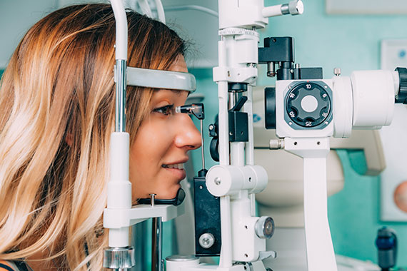 Eine Frau stützt ihr Kinn auf ein Augenuntersuchungsgerät, das eine genaue Bewertung ihres Augendrucks ermöglicht.