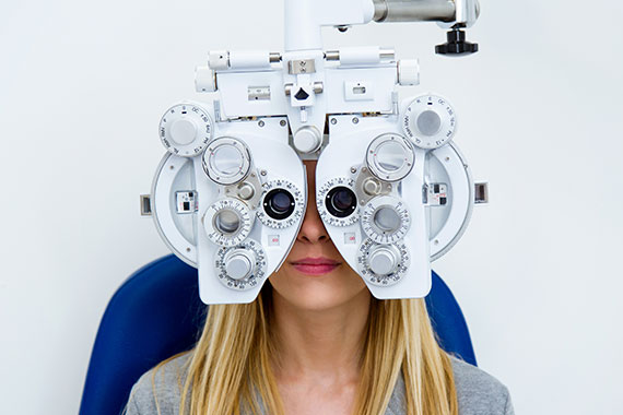 Eine Frau, die ein Gerät zur Augenuntersuchung auf dem Kopf trägt, das eine genaue Beurteilung der Sehkraft ermöglicht.